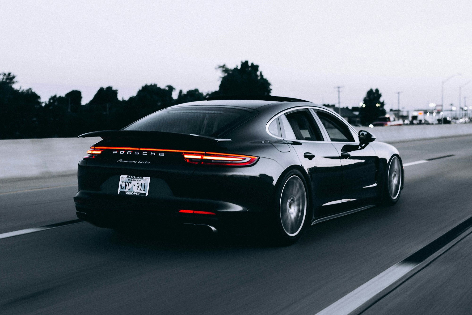 Porsche oscuro en carretera; fotografía ilustrativa, no inventario real